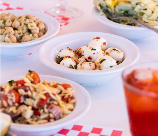 Several bowls of small snacks, including marinated mozzarella and chickpeas.